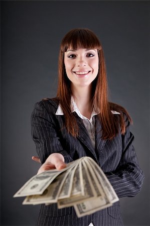 stretching a dollar - Cheerful business woman with dollars offering credit, studio shot Stock Photo - Budget Royalty-Free & Subscription, Code: 400-05933129