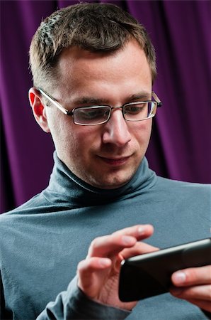 dmitryelagin (artist) - Man portrait with cellphone in arms with purple curtain on background Stock Photo - Budget Royalty-Free & Subscription, Code: 400-05947461