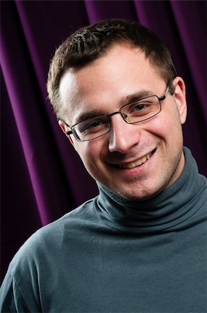 dmitryelagin (artist) - Smiling man with glasses portrait with purple curtain on background Stock Photo - Budget Royalty-Free & Subscription, Code: 400-05947462