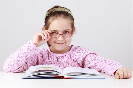 simsearch:400-04131892,k - Cute schoolgirl with glasses reading book Stockbilder - Microstock & Abonnement, Bildnummer: 400-06064744