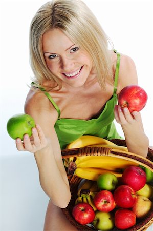pretty women eating banana - woman holds a basket of fruit on a white background Photographie de stock - Aubaine LD & Abonnement, Code: 400-06064819