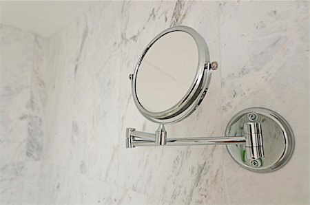 Small makeup mirror hanging from the wall of a modern bathroom with white marble tiles Foto de stock - Super Valor sin royalties y Suscripción, Código: 400-06065624