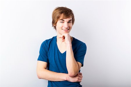 simsearch:400-05912369,k - Portrait of a casual young man with a happy face, over a white wall Fotografie stock - Microstock e Abbonamento, Codice: 400-06065856