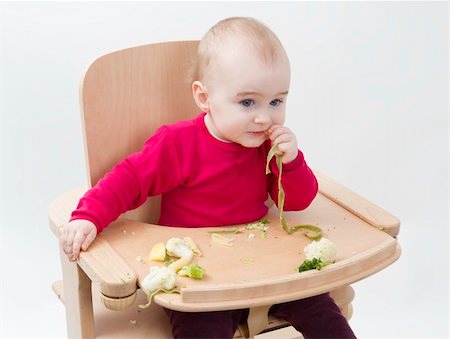 young child in red shirt eating vegetables in wooden chair. Stock Photo - Budget Royalty-Free & Subscription, Code: 400-06066535