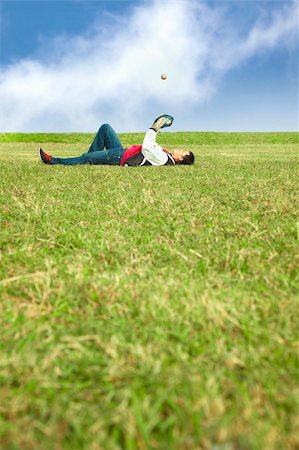 simsearch:400-04263545,k - young man lying on the grass field and playing baseball Stock Photo - Budget Royalty-Free & Subscription, Code: 400-06066679