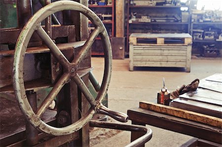 An old factory interior and a part of obsolete heavy machinery with control metal wheel Stock Photo - Budget Royalty-Free & Subscription, Code: 400-06066733