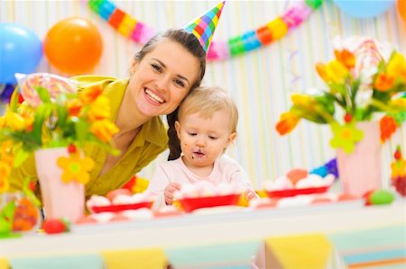 simsearch:400-06086432,k - Smiling mom and eat smeared baby on birthday celebration party Stockbilder - Microstock & Abonnement, Bildnummer: 400-06067094