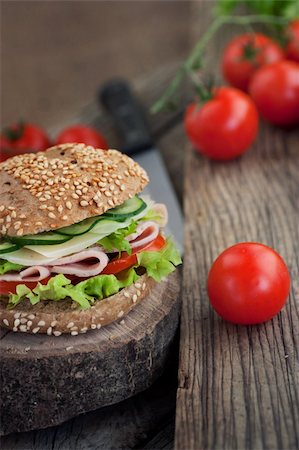 sándwich club - Delicious ham, cheese and salami sandwich with vegetables, lettuce, cherry tomatoes in natural setting with wooden background Foto de stock - Super Valor sin royalties y Suscripción, Código: 400-06067566