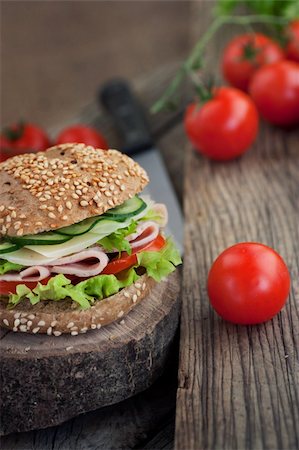 simsearch:400-08014878,k - Delicious ham, cheese and salami sandwich with vegetables, lettuce, cherry tomatoes in natural setting with wooden background Foto de stock - Royalty-Free Super Valor e Assinatura, Número: 400-06067566