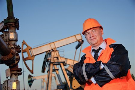 Oil worker in orange uniform and helmet on of background the pump jack and blue sky. Photographie de stock - Aubaine LD & Abonnement, Code: 400-06069109
