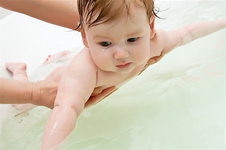 Infant holding with woman hands preparing to dive in bath Stock Photo - Budget Royalty-Free & Subscription, Code: 400-06069414
