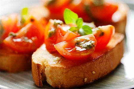 juicy tomatoes on fresh bread, pesto as topping Foto de stock - Super Valor sin royalties y Suscripción, Código: 400-06060992