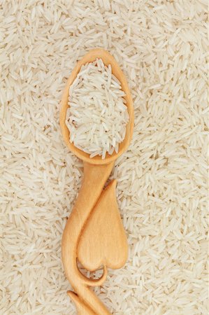 simsearch:400-07993665,k - Long grain white rice in a heart shaped wooden spoon and forming a background. Fotografie stock - Microstock e Abbonamento, Codice: 400-06061788