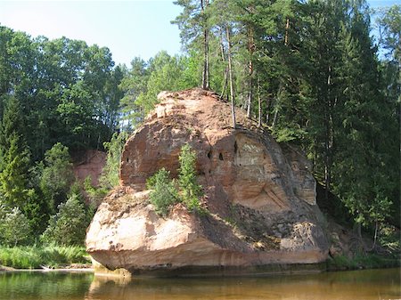 scars - Zvarta Rock is one of the most spectacular outcrops of Devon rock formations in Latvia, set in the territory of the Gauja National Park. The Zvarta Rock has been formed by the River Amata gnawing at the sandstone on its banks. Stock Photo - Budget Royalty-Free & Subscription, Code: 400-06061802
