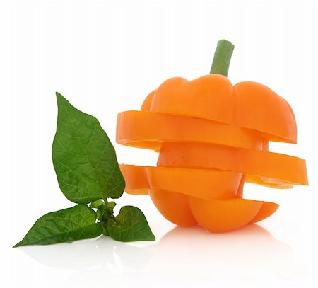 simsearch:400-06061963,k - Sliced orange capsicum with leaf sprig over white background. Foto de stock - Royalty-Free Super Valor e Assinatura, Número: 400-06061813