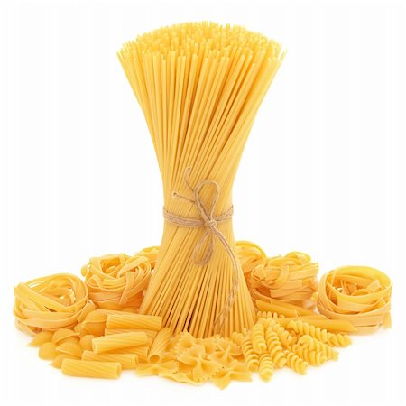 staple - Spaghetti tied in a bunch with string and tagliatelle, conchiglie, rigatoni, farfalle, fusilli and penne pasta  scattered over white background. Photographie de stock - Aubaine LD & Abonnement, Code: 400-06061829