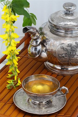 Green tea in a cup, flowers, yellow acacia on a bamboo tray Photographie de stock - Aubaine LD & Abonnement, Code: 400-06062167