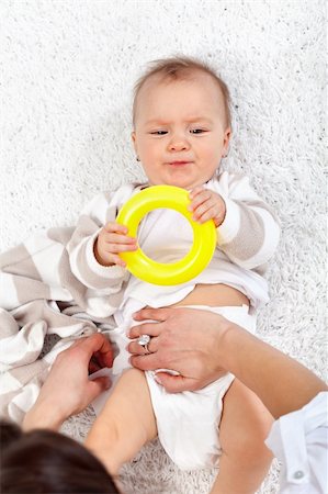 diaper girl change - Woman changing diapers on an impatient baby girl - top view Stock Photo - Budget Royalty-Free & Subscription, Code: 400-06062999