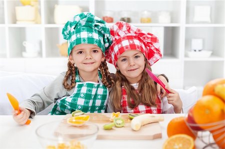 Little chef girls slicing fruits in the kitchen - healthy eating Photographie de stock - Aubaine LD & Abonnement, Code: 400-06063006