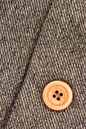 simsearch:400-05219954,k - Close-up photograph of an orange button on gray fabric. Add your text to the background. Foto de stock - Super Valor sin royalties y Suscripción, Código: 400-06063458