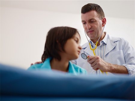 doctor measuring boy - Friendly caucasian doctor working and visiting with stethoscope sick child in medical office. Focus on foreground Stock Photo - Budget Royalty-Free & Subscription, Code: 400-06063731