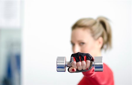Woman in red training outfit working out with dumbbell holding it straight in front of her face. Focus is on dumbbell. Stock Photo - Budget Royalty-Free & Subscription, Code: 400-06074301