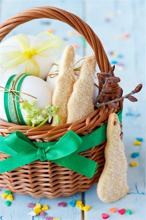 simsearch:400-07422530,k - Easter bunny cookies, eggs with ribbon in a basket on an blue  wooden board. Fotografie stock - Microstock e Abbonamento, Codice: 400-06075571