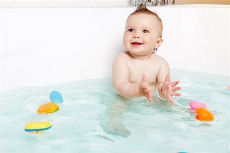 Cute baby clapping hands and smiling while taking a bath Stock Photo - Budget Royalty-Free & Subscription, Code: 400-06075954