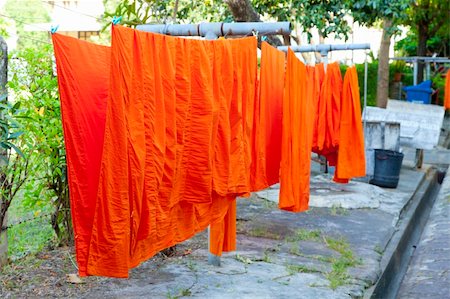 Orange robes of Buddhist monks are drying at the grounds of Marble Temple in Bangkok, Thailand Stock Photo - Budget Royalty-Free & Subscription, Code: 400-06076505