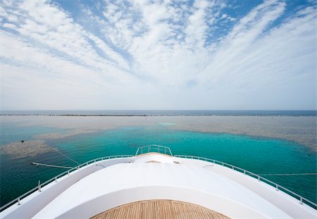 View from the bow of a large private motor yacht on tropical sea with cloudy sky Photographie de stock - Aubaine LD & Abonnement, Code: 400-06076860