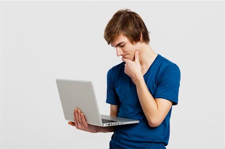 simsearch:400-05912400,k - Handsome young man holding and working with a laptop, isolated over a white background Photographie de stock - Aubaine LD & Abonnement, Code: 400-06077626