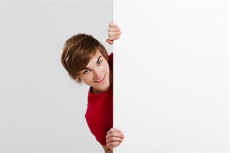 simsearch:400-05368656,k - Happy young hiding and looking behind a blank white card Stockbilder - Microstock & Abonnement, Bildnummer: 400-06077636