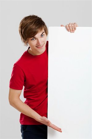 simsearch:400-05368656,k - Portrait of a happy young man showing something on a blank white card Stockbilder - Microstock & Abonnement, Bildnummer: 400-06077631