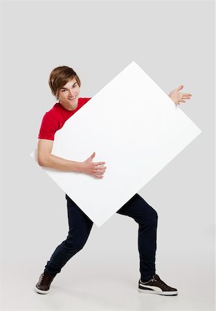 Portrait of a happy young man holding and playing with a blank white card Stock Photo - Budget Royalty-Free & Subscription, Code: 400-06077633