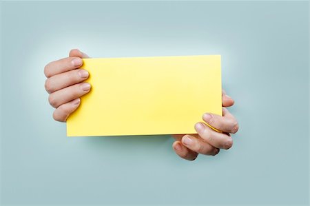 Strange hands holding a yellow card. Stock Photo - Budget Royalty-Free & Subscription, Code: 400-06077741