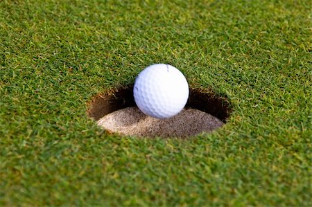 A golf ball is going in an hole Stock Photo - Budget Royalty-Free & Subscription, Code: 400-06077770