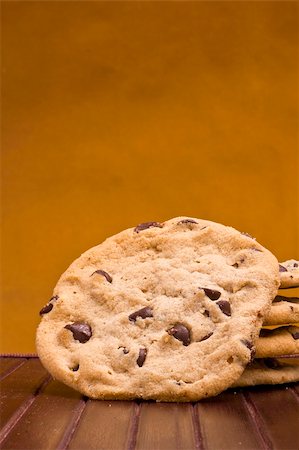 simsearch:400-04637126,k - Close-up photograph of chocolate chip cookies with an orange background. Stockbilder - Microstock & Abonnement, Bildnummer: 400-06079527