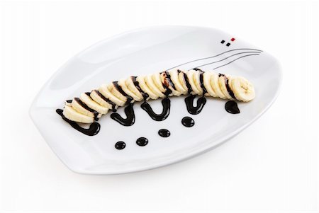 Sliced banana with chocolate sauce on a white plate Stock Photo - Budget Royalty-Free & Subscription, Code: 400-06070285