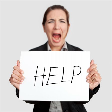 simsearch:400-04343341,k - Stressed business woman imploring for help, holding a cardboard with the message "Help". Focus is on the cardboard Foto de stock - Super Valor sin royalties y Suscripción, Código: 400-06070488