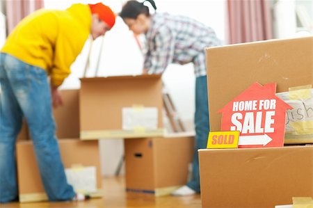 family with sold sign - Home for sale sign with sold sticker and unpacking young family in background Stock Photo - Budget Royalty-Free & Subscription, Code: 400-06070585