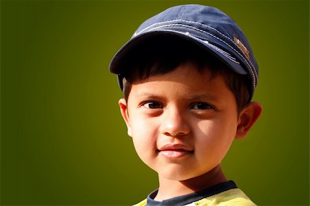 simsearch:400-05745952,k - Photo of handsome indian boy with a cap smiling with copy space Stock Photo - Budget Royalty-Free & Subscription, Code: 400-06071033