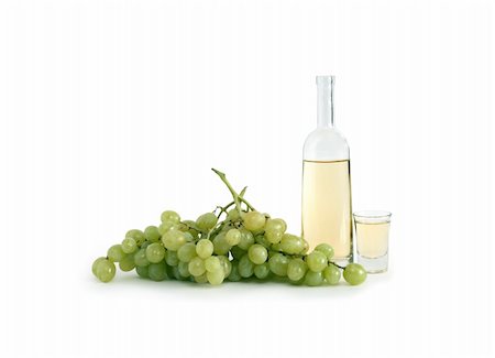 Open bottle of Italian vodka ?grappa? near wineglass and bunch of grapes on white background. Clipping path is included Stock Photo - Budget Royalty-Free & Subscription, Code: 400-06071055