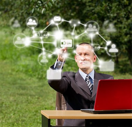 symbols of multimedia - Man with red laptop in social networks outdoors, pushs the button Photographie de stock - Aubaine LD & Abonnement, Code: 400-06073630