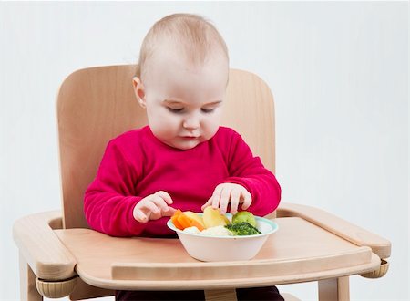 young child in red shirt eating vegetables in wooden chair. Stock Photo - Budget Royalty-Free & Subscription, Code: 400-06073819
