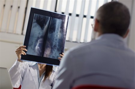 simsearch:400-04905106,k - mid adult woman at work as doctor in office and examining x-rays with patient Stock Photo - Budget Royalty-Free & Subscription, Code: 400-06084643