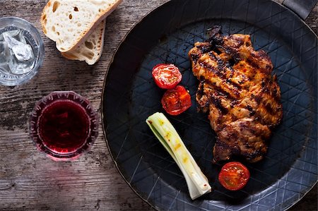 striped tomato - grilled pork steak in an iron pan Stock Photo - Budget Royalty-Free & Subscription, Code: 400-06084818