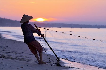 Silhouette of a fisherman on beach at sunrise Stock Photo - Budget Royalty-Free & Subscription, Code: 400-06085351