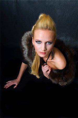 simsearch:400-05051542,k - Young blond woman with fur, professional hair and makeup, on dark background. Focus on model's eyes. Stock Photo - Budget Royalty-Free & Subscription, Code: 400-06085566