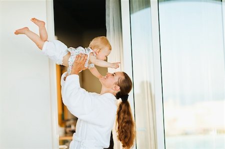 simsearch:400-06067090,k - Mother in bathrobe playing with baby on terrace Stockbilder - Microstock & Abonnement, Bildnummer: 400-06086441