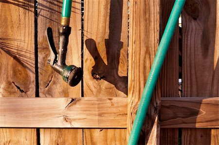 Wood fence and garden hose with spray nozzle. Stock Photo - Budget Royalty-Free & Subscription, Code: 400-06086731